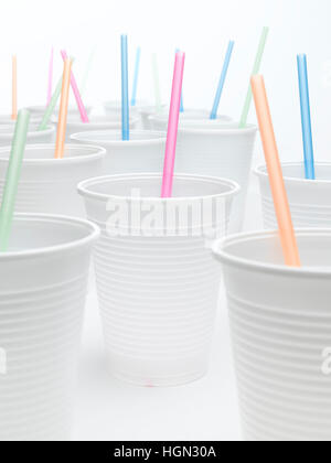 Verres en plastique avec paille sur fond blanc Banque D'Images