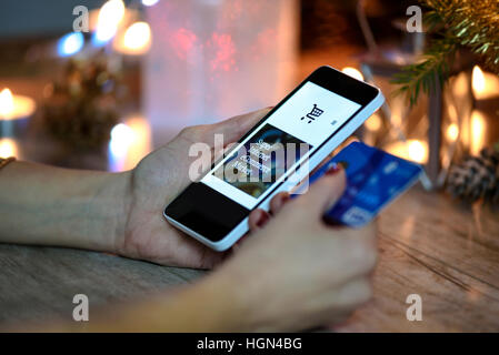 Femme fait des achats de Noël via smartphone et d'une carte de crédit dans le magasin en ligne Banque D'Images