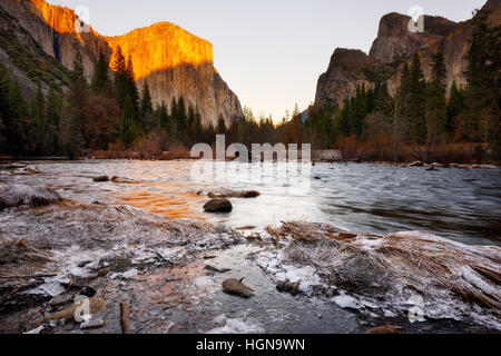 Coucher de soleil à Valley View, Yosemite National Park, California, USA. Rivière et le groupe de la glace et de la neige sur les bords de la rivière. Banque D'Images