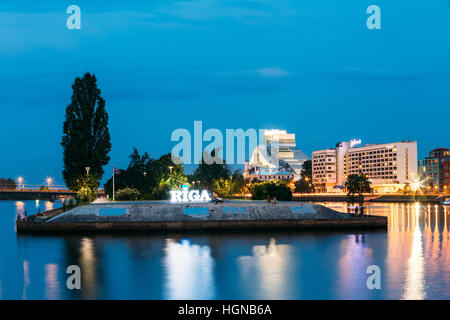 Riga, Lettonie - 30 juin 2016 : le paysage urbain pittoresque dans l'éclairage en soirée. Vue de l'aménagement urbain Quai de la rivière Daugava, Ardent Nom Ville Sign In Summ Banque D'Images