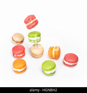 Différents types de macarons dans motion relevant sur fond blanc. Dessert traditionnel français isolé sur blanc avec espace pour texte. Banque D'Images