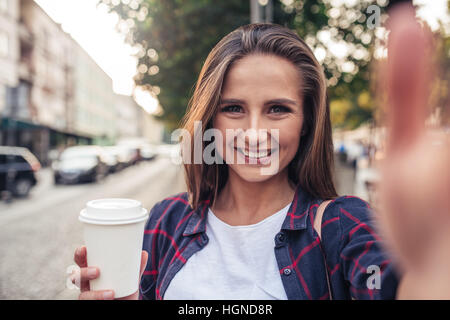 Jeune femme tenant une dans la ville selfies Banque D'Images
