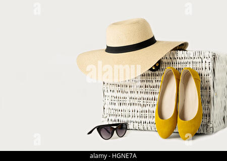 Valise en osier blanc, womens chapeau, lunettes de soleil et les chaussures jaunes. Banque D'Images