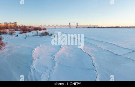 Frozen river Northern Dvina et pont de chemin de fer à Arkhangelsk, Russie. Coup d'hiver. Banque D'Images