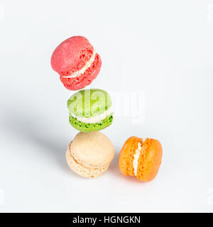 Différents types de macarons dans motion relevant sur fond blanc. Dessert traditionnel français isolé sur blanc avec espace pour texte. Banque D'Images