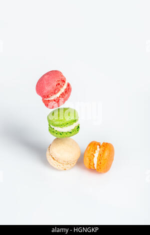 Différents types de macarons dans motion relevant sur fond blanc. Dessert traditionnel français isolé sur blanc avec espace pour texte. Banque D'Images