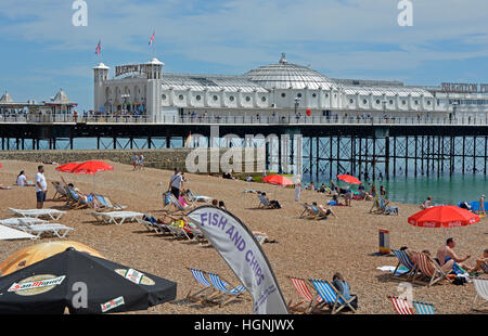 Front de Mer et plage de galets à Brighton dans l'East Sussex, Angleterre. Avec pier et les gens on beach Banque D'Images