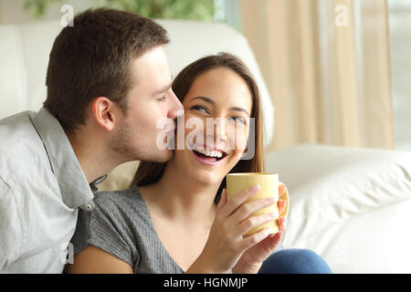 Heureux mari embrasser sa femme dans la salle de séjour à la maison. Couple heureux concept Banque D'Images