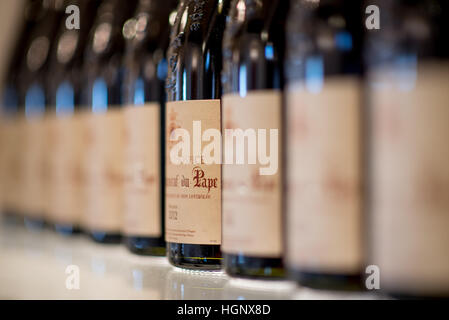 Les bouteilles de vin dans une rangée sur une étagère l'accent peu profondes Banque D'Images
