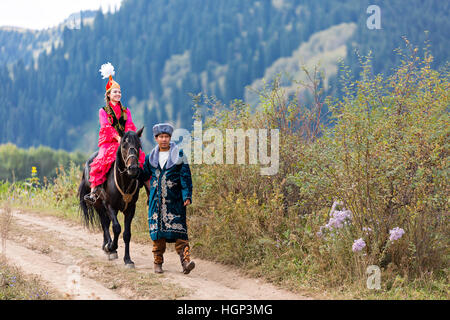 Couple kazakh en costumes nationaux avec une femme locale sur le cheval, Kazakhstan Banque D'Images