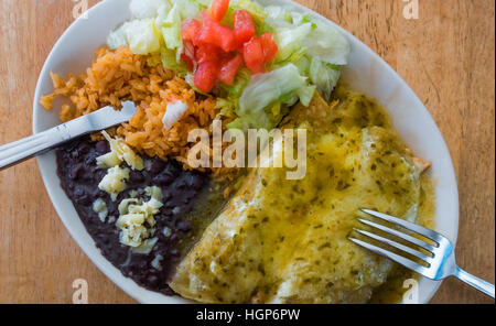 Les enchiladas Suizas avec les haricots noirs, le riz brun, et salade Banque D'Images