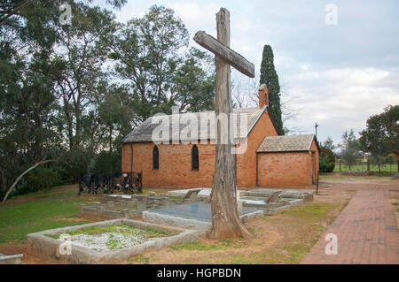 Vue de côté de l'église All Saints avec de grandes croix de bois dans le cimetière à la tombée de la Henley Brook, dans l'ouest de l'Australie. Banque D'Images