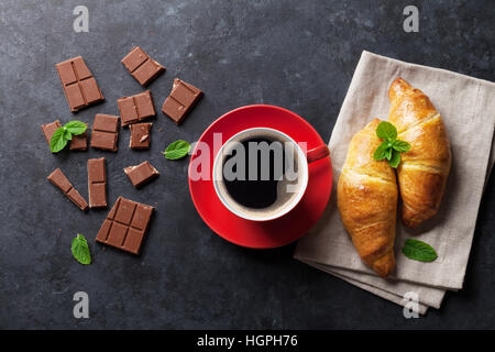 Chocolat, croissants et café tasse sombre sur fond de pierre. Vue d'en haut Banque D'Images