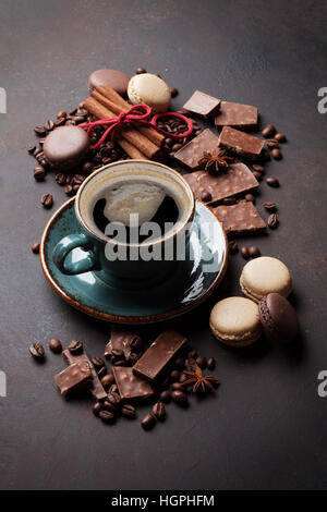 Tasse à café, les haricots, le chocolat et les macarons sur la vieille table de cuisine Banque D'Images