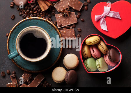 Tasse à café, les haricots, le chocolat, les macarons et boîte-cadeau sur la vieille table de cuisine. Vue d'en haut Banque D'Images