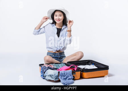 Young smiling woman in casual clothes sitting down transporteur emballage Banque D'Images