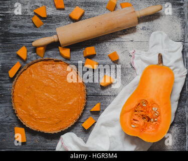 Coup de frais généraux de la citrouille, la courge musquée les morceaux de potiron, Rolling pin gris rustique sur table en bois. La cuisson au four, tarte maison en automne Banque D'Images