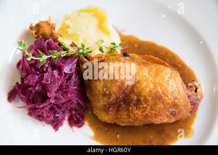 Confit de canard avec purée de pommes de terre et chou mauve on white plate Banque D'Images