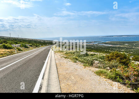 Route menant à la mer. Locations de voyager sur route asphaltée vers la baie bleue de la Méditerranée en mer Adriatique - Croatie. Banque D'Images