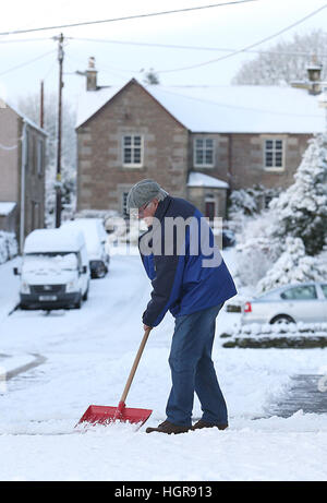 Jack Maxwell élimine la neige de son allée de Braco, près de Stirling, car les conditions de blizzard sont sur le point de donner « un vrai goût de l'hiver à l'ensemble du Royaume-Uni ». Banque D'Images