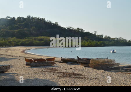 Des pirogues en bois sur les rives de la plage Andilana à Nosy Be, Madagascar. Banque D'Images