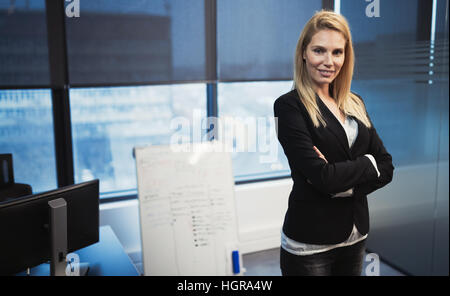 Blond businesswoman in office avec succès sur le lieu de travail Banque D'Images