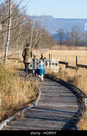 Mère et 3 enfants Trois enfants filles sur voie passerelle sentier sentier Marais de Lavours Réserve naturelle nationale. France Banque D'Images