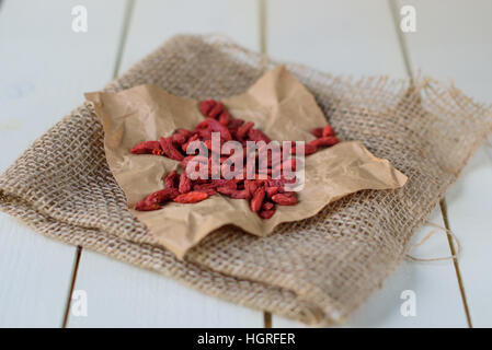 Les baies de Goji sur fond de bois blanc. Wolf berry Banque D'Images
