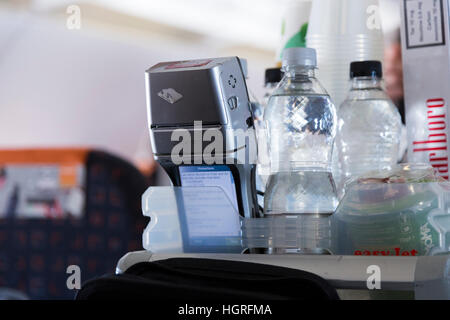 Appareil terminal de paiement Argent & trolley panier. Prendre l'air de l'équipage de cabine passager avec la carte de crédit pour les boissons collations vol Easyjet Banque D'Images