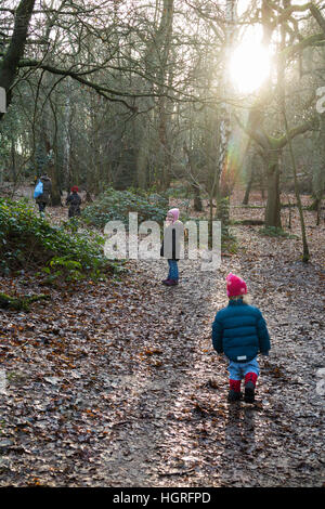 Mère et 3 enfants Trois enfants filles / marche à pied le long du chemin boueux / dans la boue sur la voie de chemin de ronde pied sentier Esher UK Banque D'Images