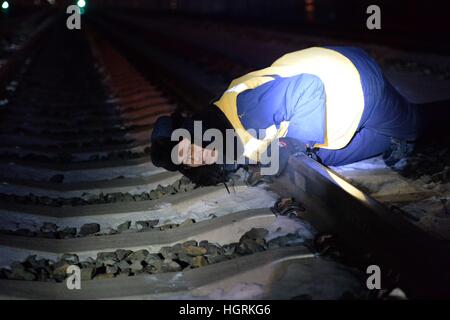 Harbin, Chine. 12 Jan, 2017. Un poseur de Harbin Railway Bureau international vérifie la piste à Harbin, Heilongjiang Province du nord-est de la Chine le 12 janvier, 2017. La température la plus basse dans la région de Harbin a chuté à moins 20 degrés Celsius, le jeudi. Comme le froid peut provoquer des effets physiques subtiles sur les chemins de fer à grande vitesse Harbin-Dalian, les travailleurs ont d'examiner l'équipement de la voie entre 0 h 30 et 4 h 30 pour assurer le bon fonctionnement. © Wang Kai/Xinhua/Alamy Live News Banque D'Images