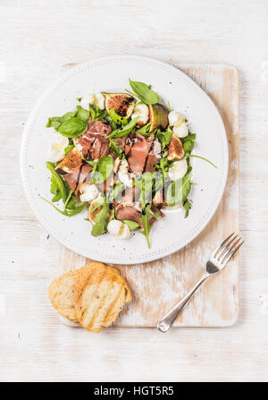 Le prosciutto, roquette, basilic, figues, salade de mozzarella servi avec du pain Banque D'Images