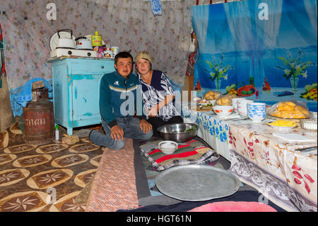 La préparation de la femme nomade kazakh table pour invités dans une yourte, Ile-Alatau Parc National, Assy Plateau, Almaty, Kazakhstan Banque D'Images