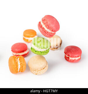 Différents types de macarons en mouvement de chute ou de voler sur fond blanc. Dessert traditionnel français isolé Banque D'Images