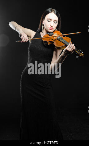 Femme en robe noire à jouer du violon Banque D'Images