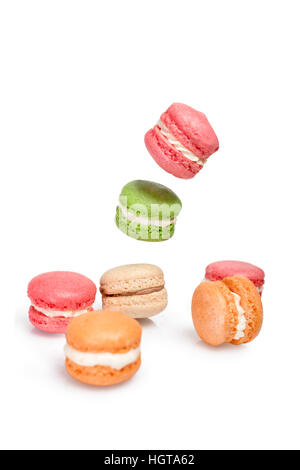 Différents types de macarons en mouvement de chute ou de voler sur fond blanc. Dessert traditionnel français isolés macarons Banque D'Images