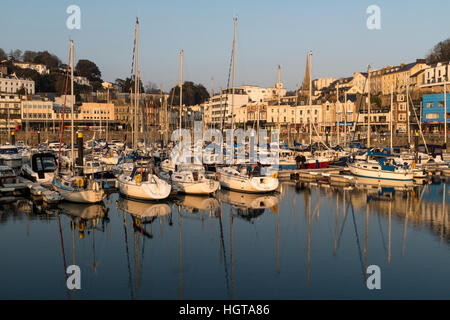 Voir la soirée de bateaux, avec des réflexions, amarré dans le port de Torquay avec les édifices ; Torquay, Devon, Angleterre. Banque D'Images