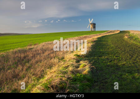 Une piste d'herbe mène au Moulin à vent de Chesterton en début de matinée sous le soleil d'hiver peu après le lever du soleil, près de Royal Leamington Spa, Warwickshire, Angleterre Banque D'Images