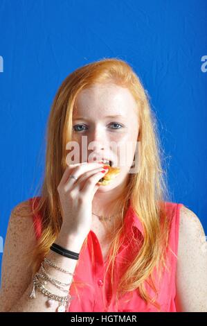 Un adolescent de manger un petit pain au chocolat Banque D'Images