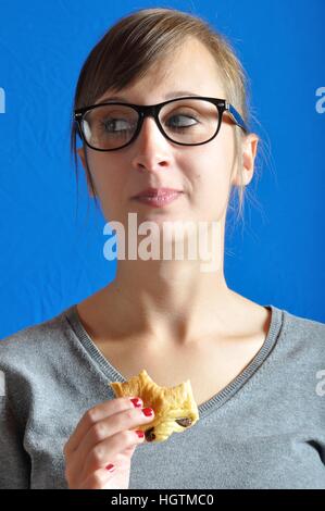 Un adolescent de manger un petit pain au chocolat Banque D'Images