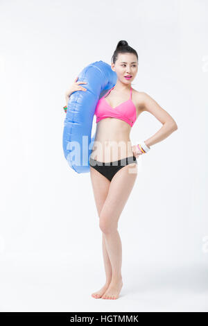 Young woman in bikini slim posant avec un tube Banque D'Images