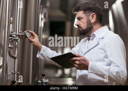 Homme sérieux travaillant dans brewery Banque D'Images