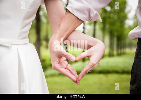 Jeune couple de mariage romantique faisant un doigt coeur ensemble Banque D'Images