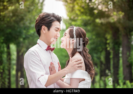 Side view portrait of young romantic couple hugging face à face à l'extérieur Banque D'Images