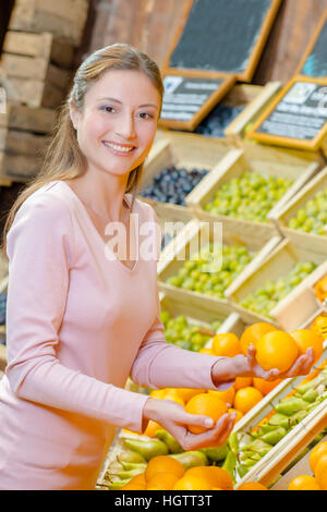 Dame choisissant oranges en magasin Banque D'Images