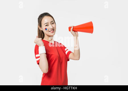 Portrait of young smiling woman holding a megaphone cheerleader Banque D'Images