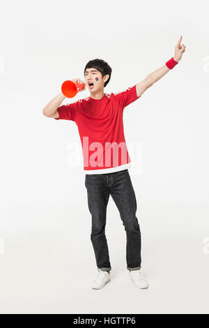 Young man holding cheerleader coréen et crier par mégaphone Banque D'Images