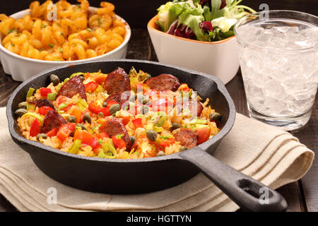 Riz au chorizo et légumes cuits dans une casserole sur fond de bois Banque D'Images