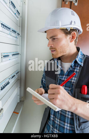 Les jeunes electrician working on panneau électrique Banque D'Images