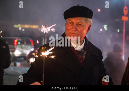 Un homme portant un béret célèbre le Nouvel An à l'extérieur de l'Hallgrimskirkja à Reykjavik, Islande, le 1er janvier 2017. Banque D'Images